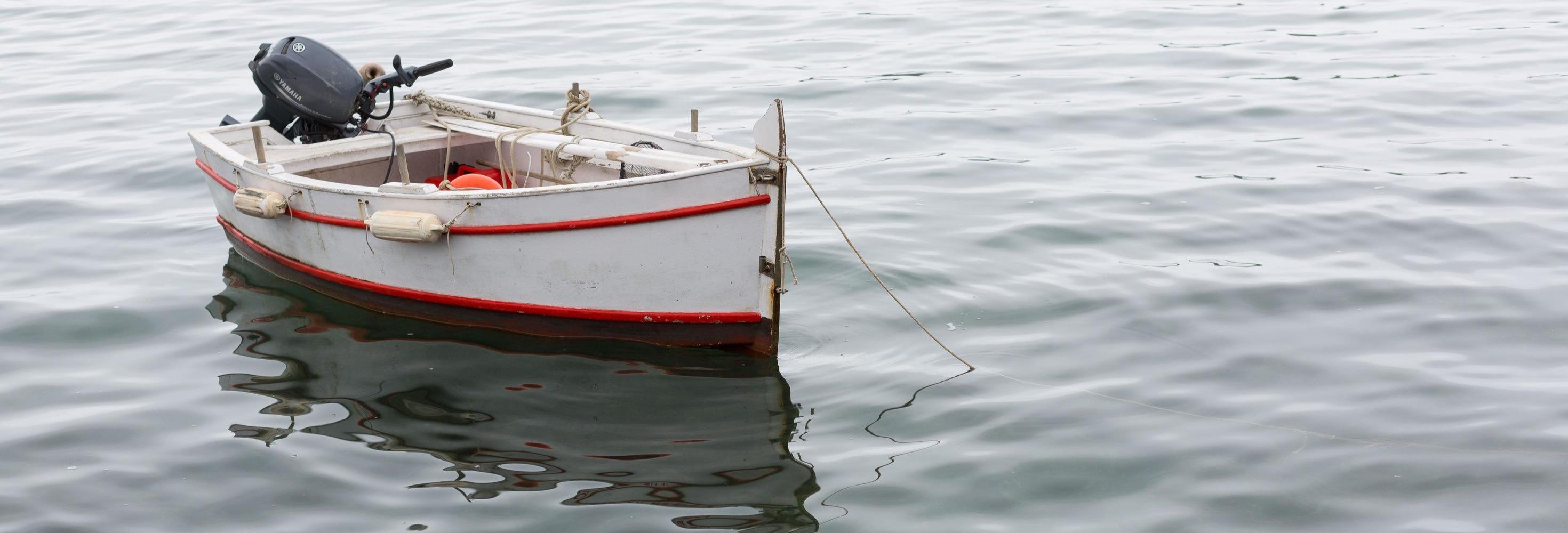 Small boat with a motor on calm water
